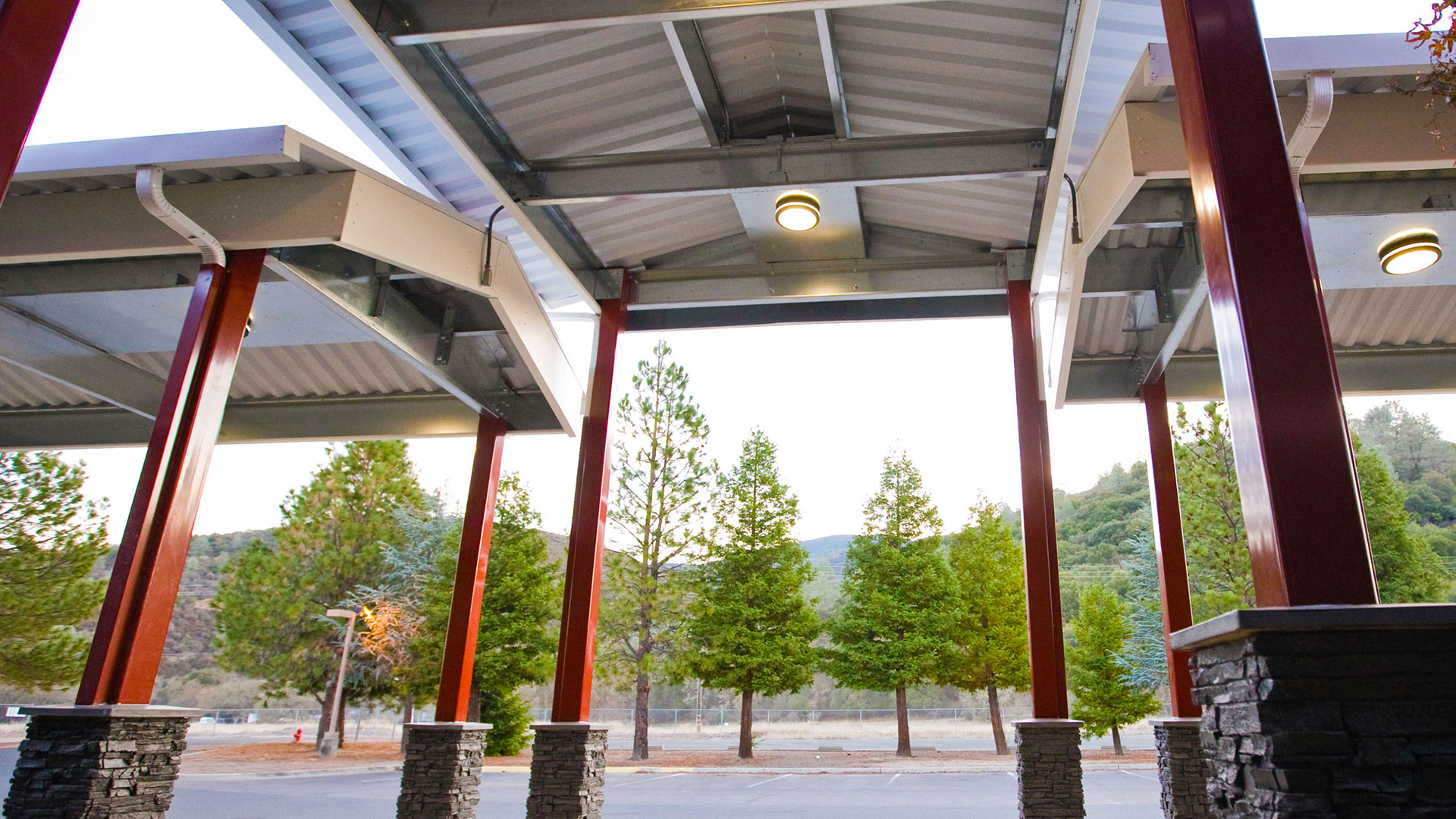 Canopies from underneath, with currogated white metal roof and lights, with seperate walkways to the left and right.