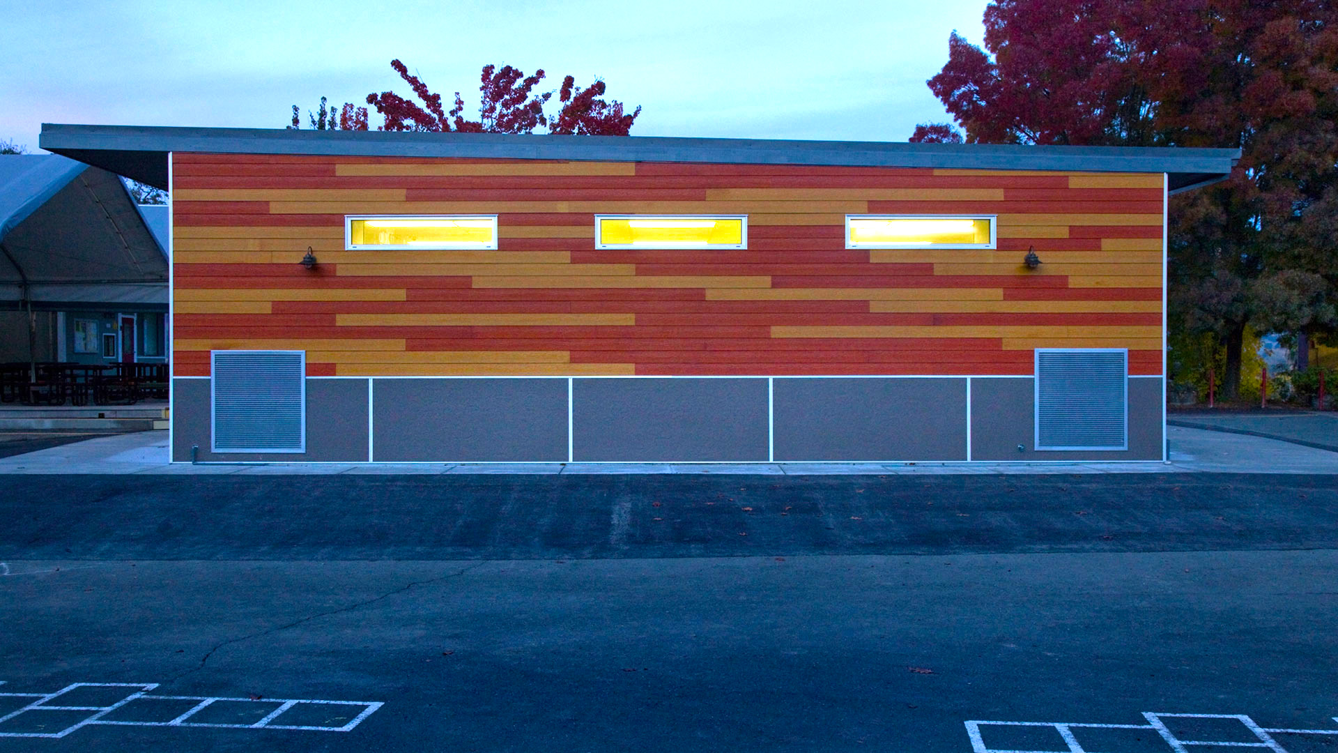 New multi-use room exterior, with wooden panel walls over gray wainscot.