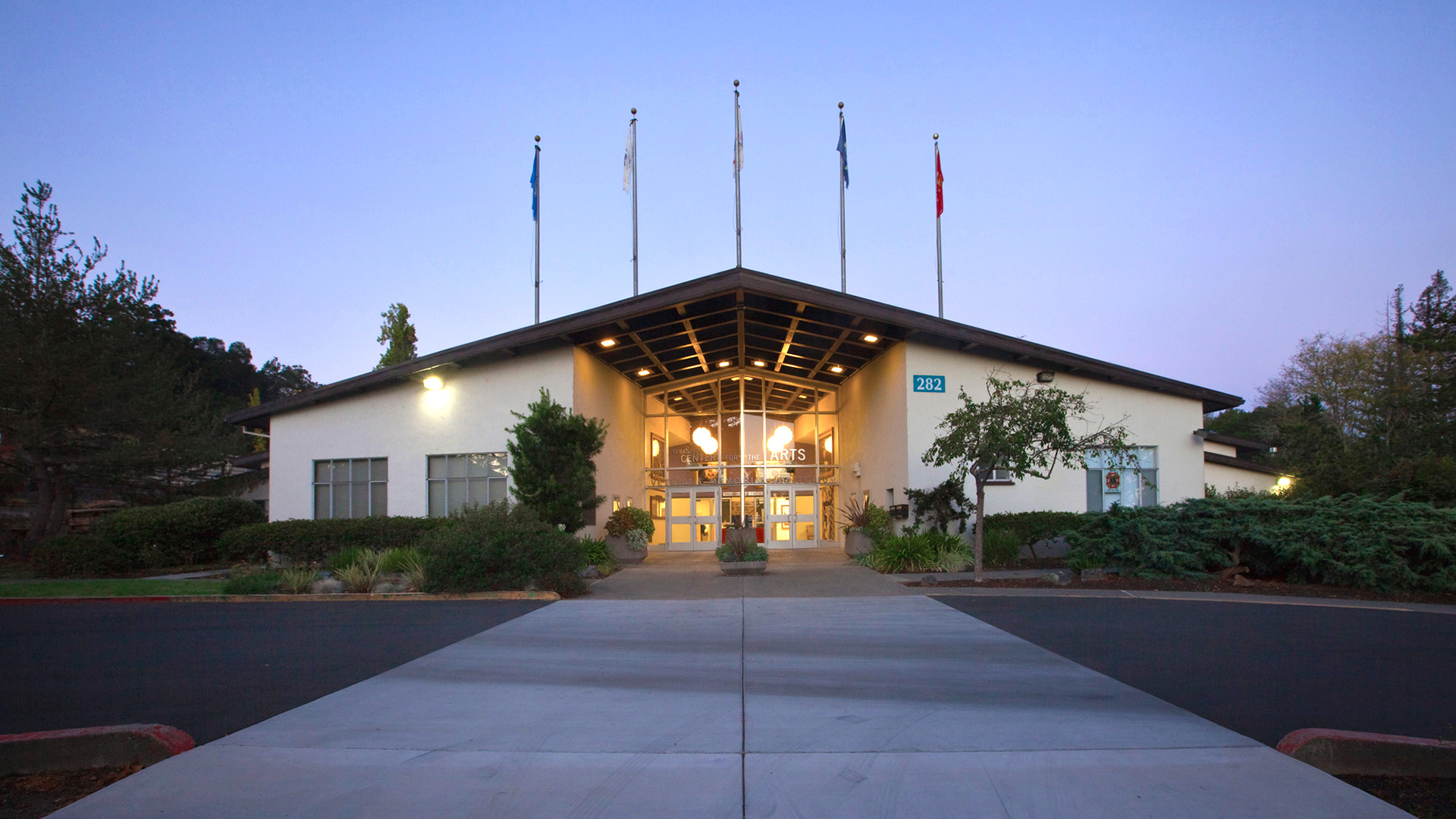 Front view of the Center for the Arts entrance, with flags extending from the roof