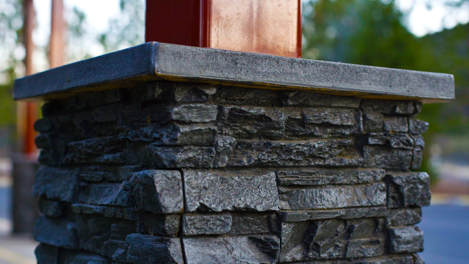 Closeup of post bases, made up of texturous gray stacked stone