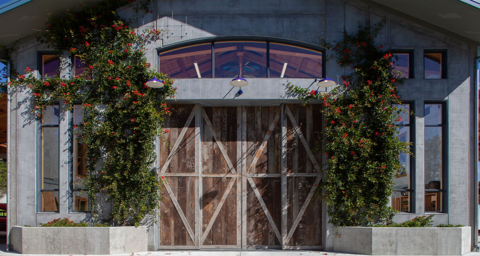 The large, wooden door to the barn, double height and width, patterned with different wood.