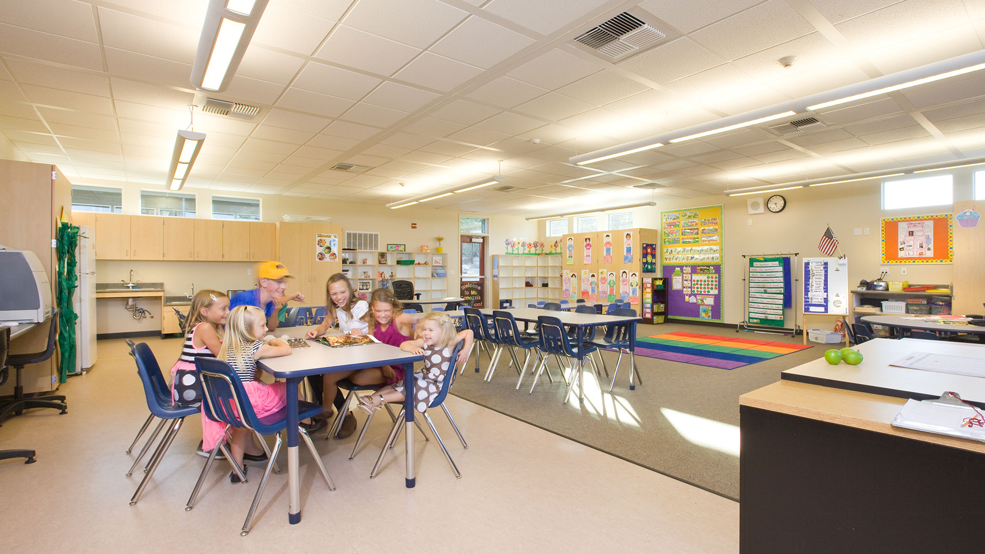 New classroom interior, with carpet and vinyl flooring for desk and seating areas.