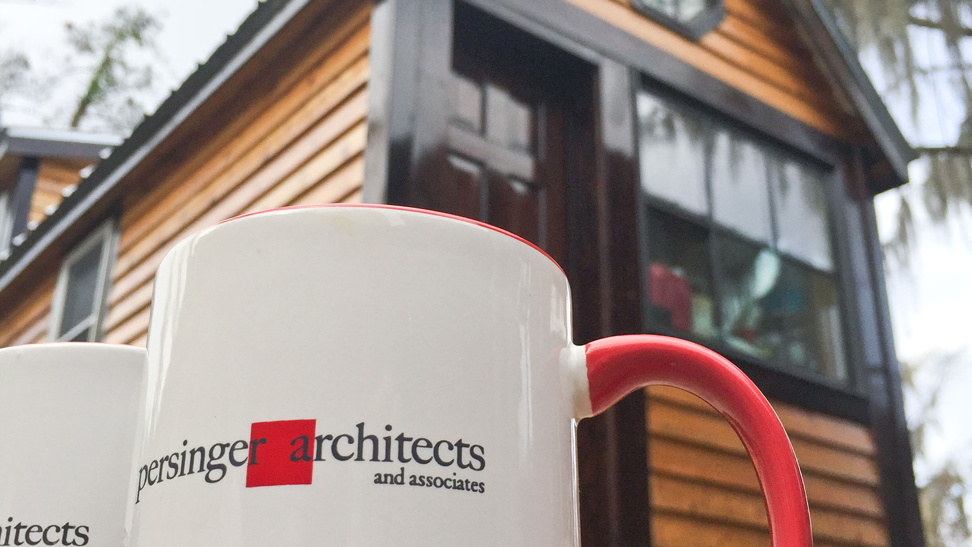 Persinger mug in foreground looking up at orange cabin behind