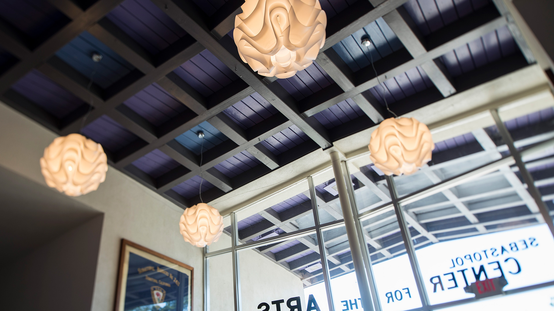 Lobby of Center for the Arts looking up at the purple ceiling with glowing paper sphere lights