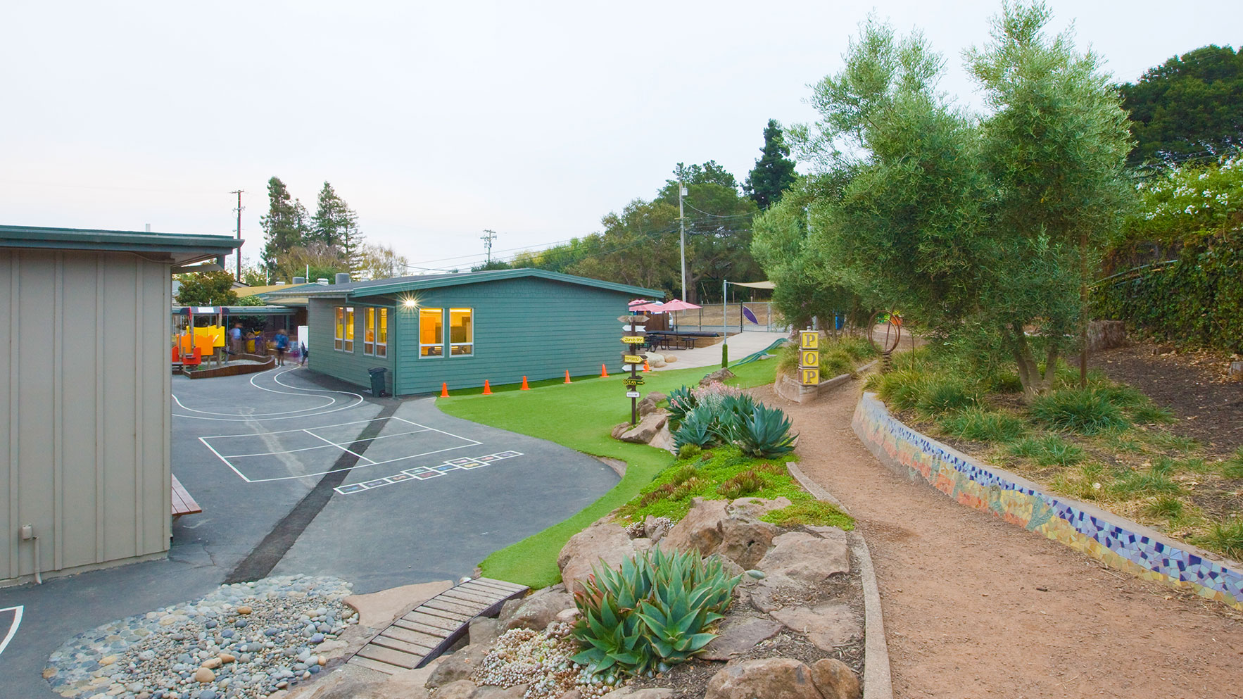 Green area with walkway and new portable building behind.