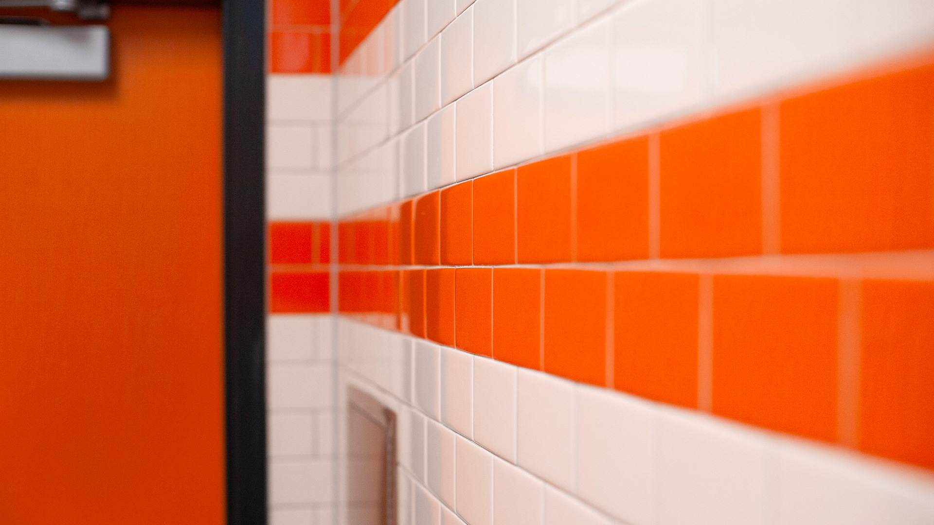Closeup of orange and white tile walls in new restrooms