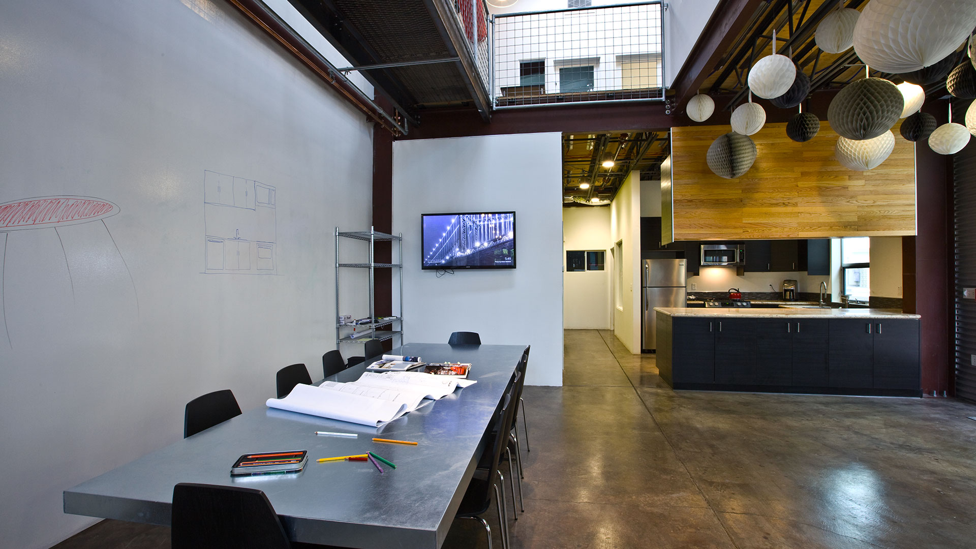 Interior of Persinger office, large metal conference table with TV behind, metal catwalk above