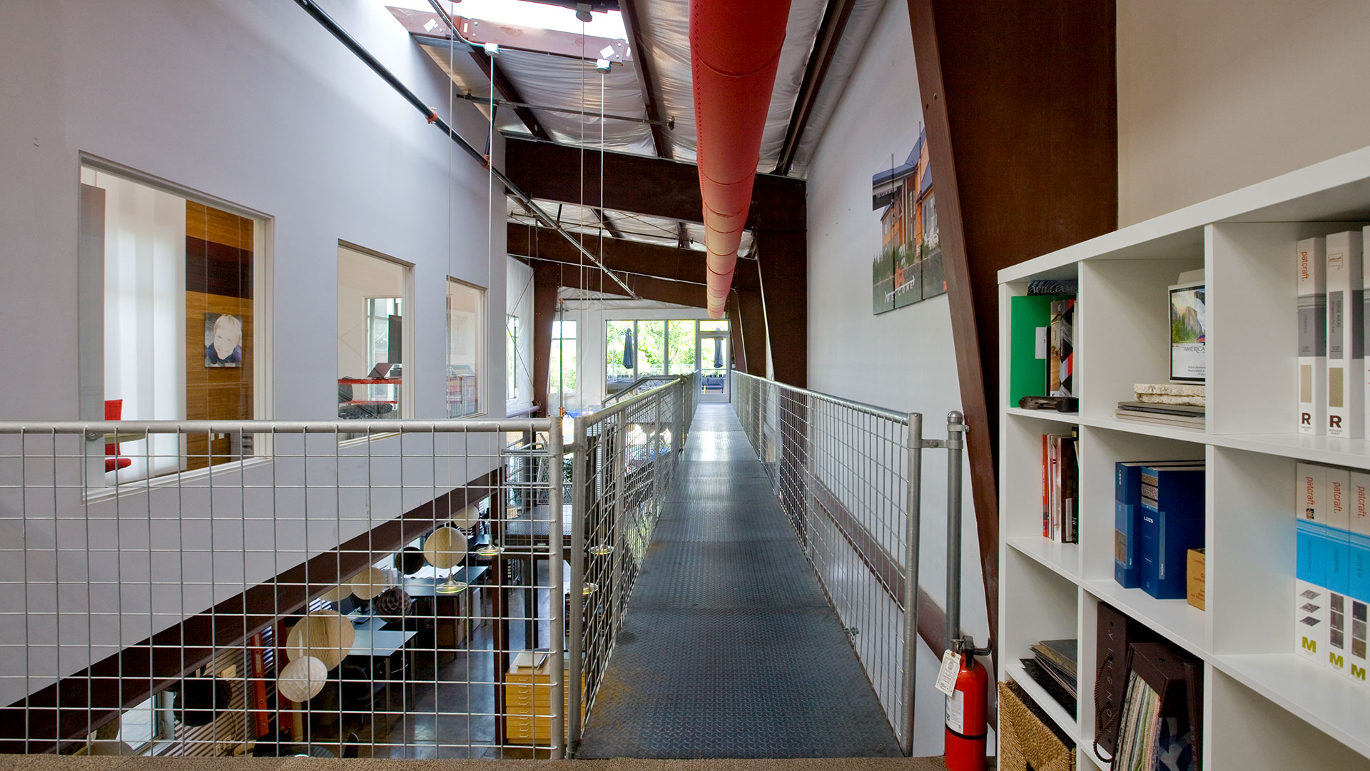 View of office upper floor, with metal catwalk and railings leading to mezzanine