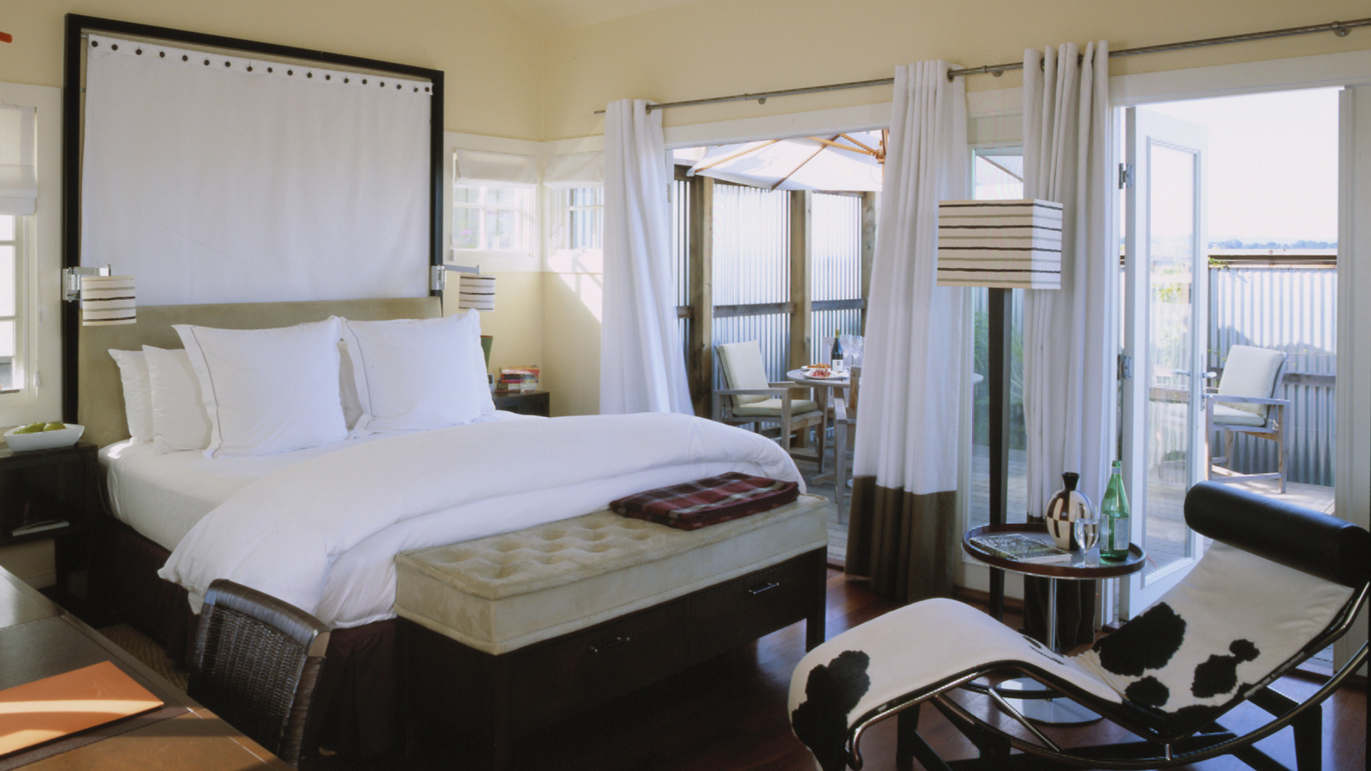 Pristine interior of cottage bedroom, white sheets and drapes