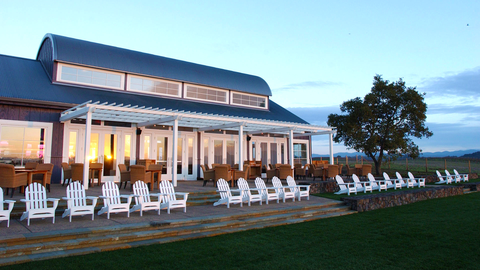 Exterior of resort seating area, lounge chairs overlooking grassy field.