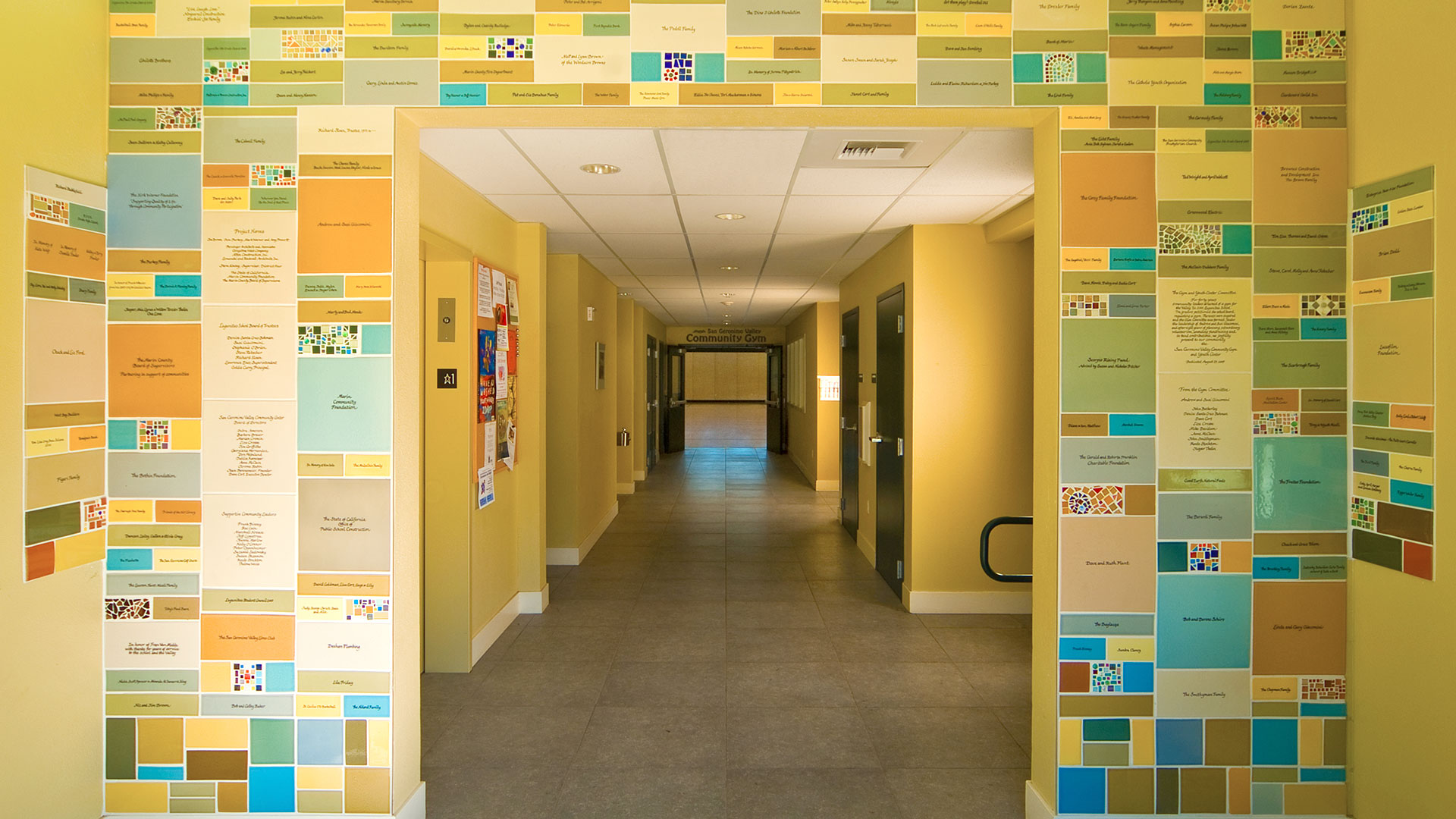 Entryway interior and archway of multicolored tiles with text.
