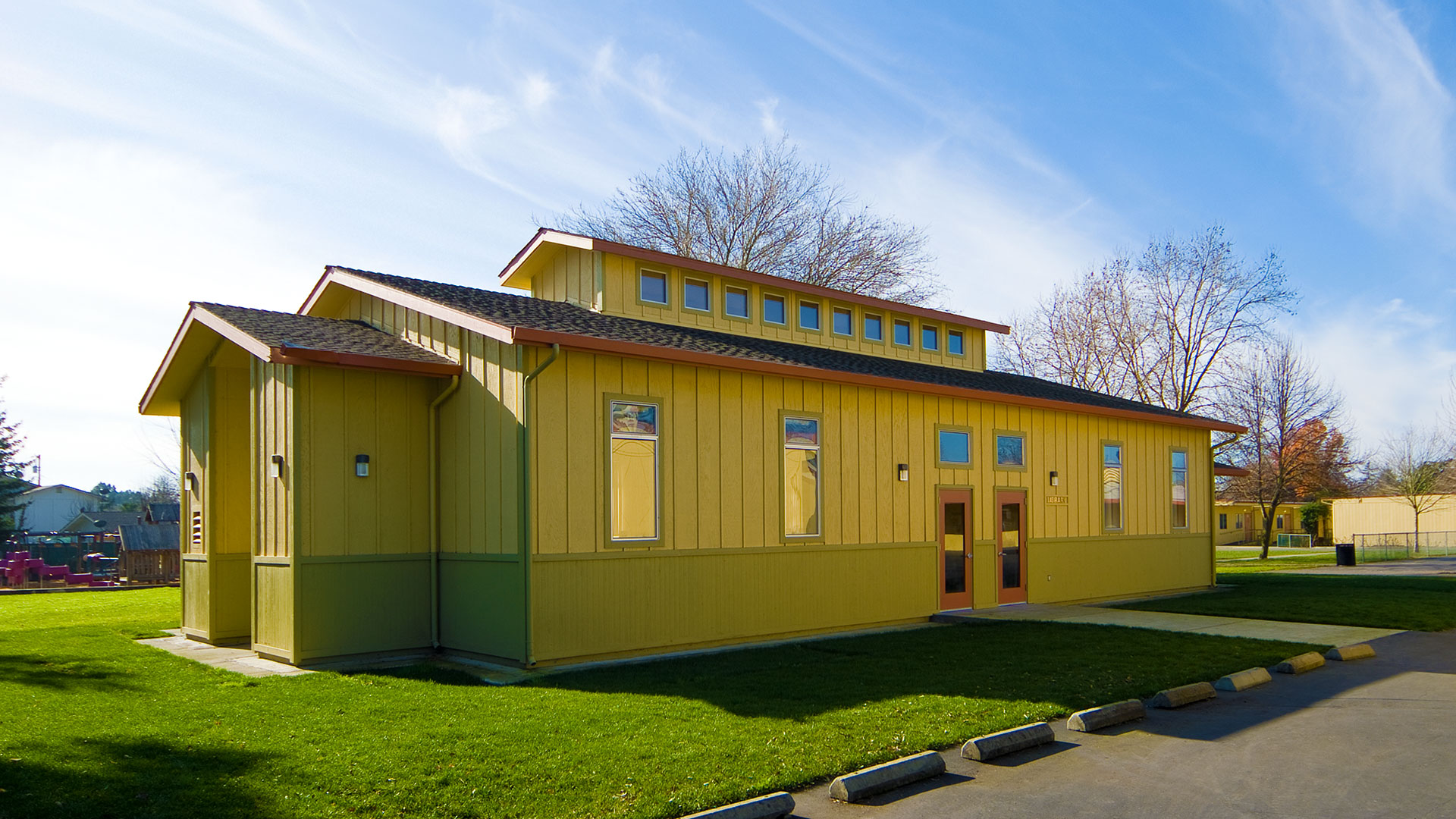 Library exterior, shaded side entrance with windowed monitor above.