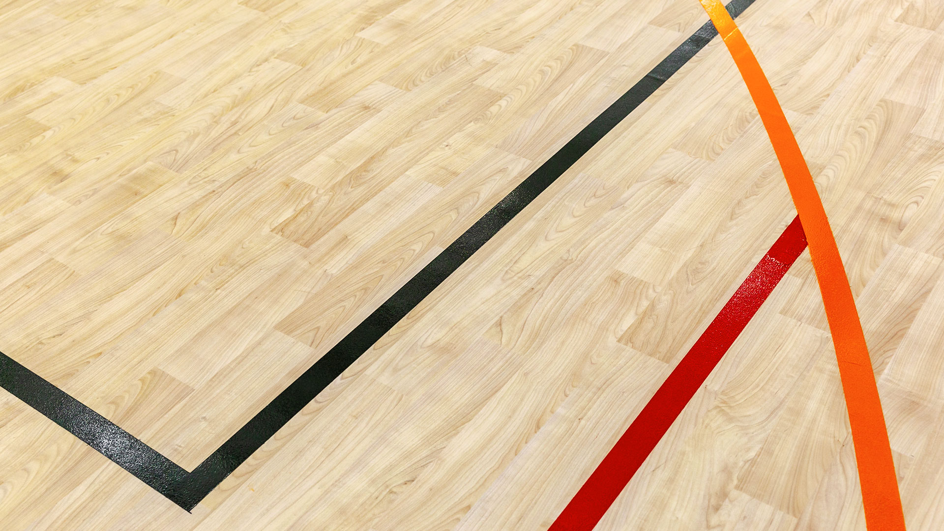 Closeup of wooden panel floor with sport striping.