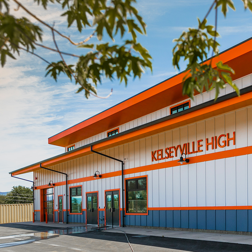 Orange and white shop exterior with leaves in the foreground.