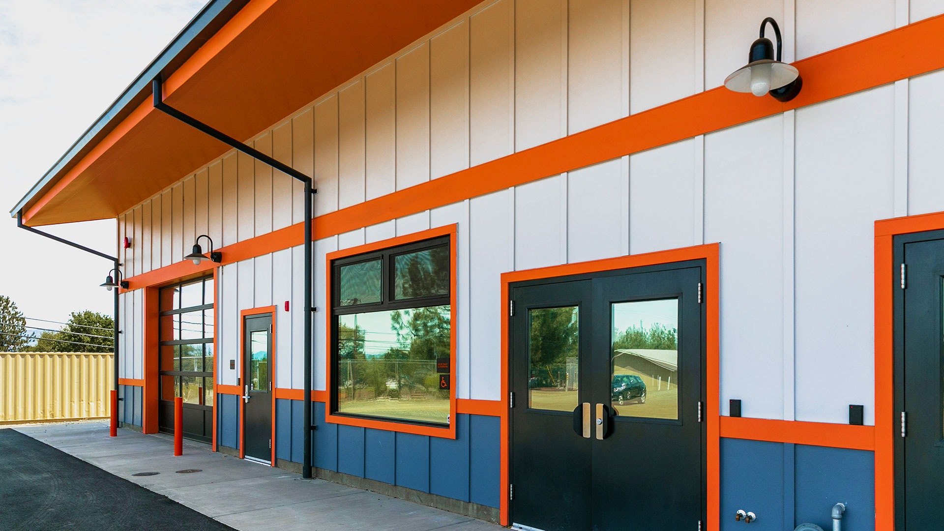 Closer shot of shop exterior double doors and large window, with protective mirror glazing.