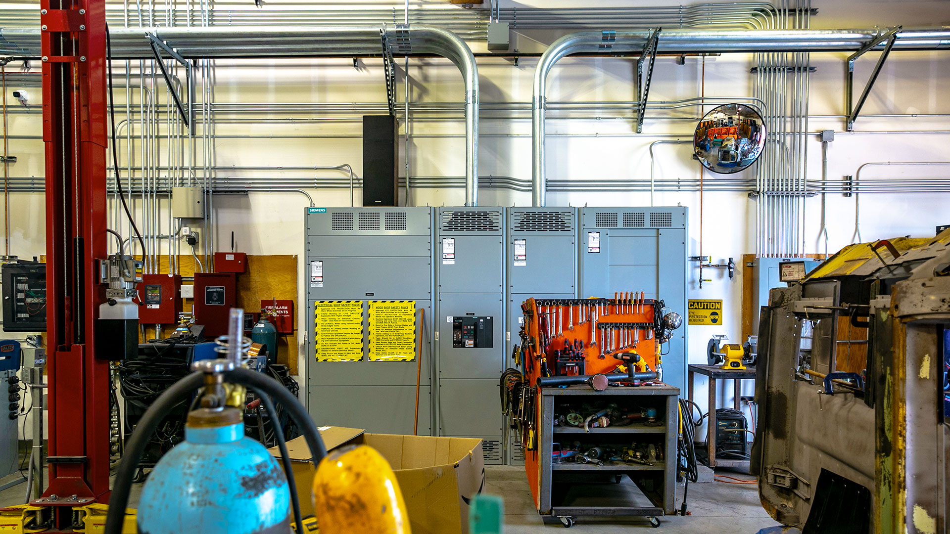 Shop interior, showing pipes running geometrically from metal power junction.