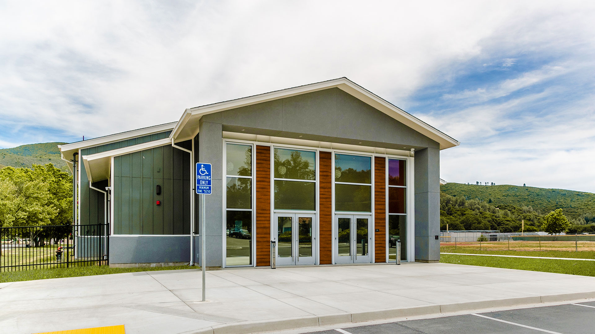 Exterior of Multi-Use Room. Gray walls with white trim and light wainscot, make up the multi-sectioned building.