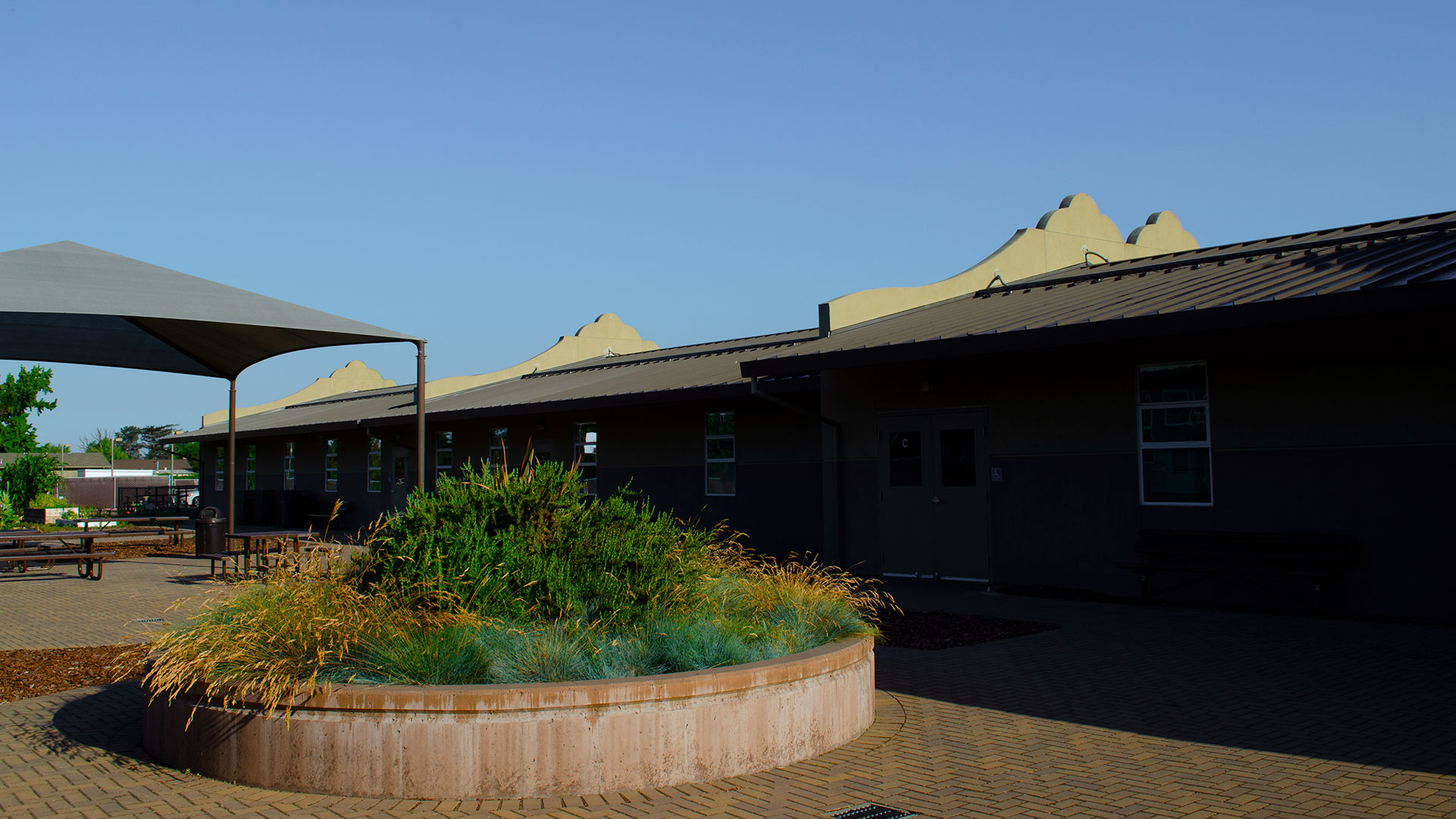 School courtyard with brick planter and seats.