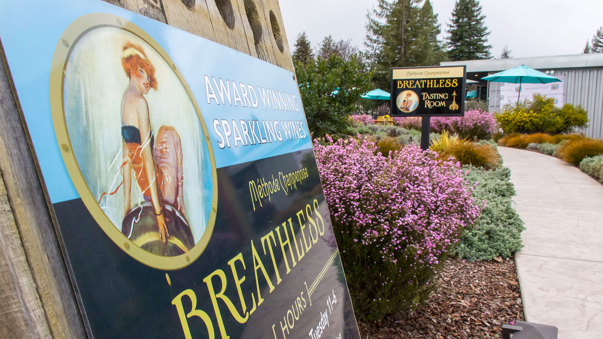 Closeup of Breathless Winery poster, 'Award Winning Sparkling Wine' and arrow pointing towards tasting room.