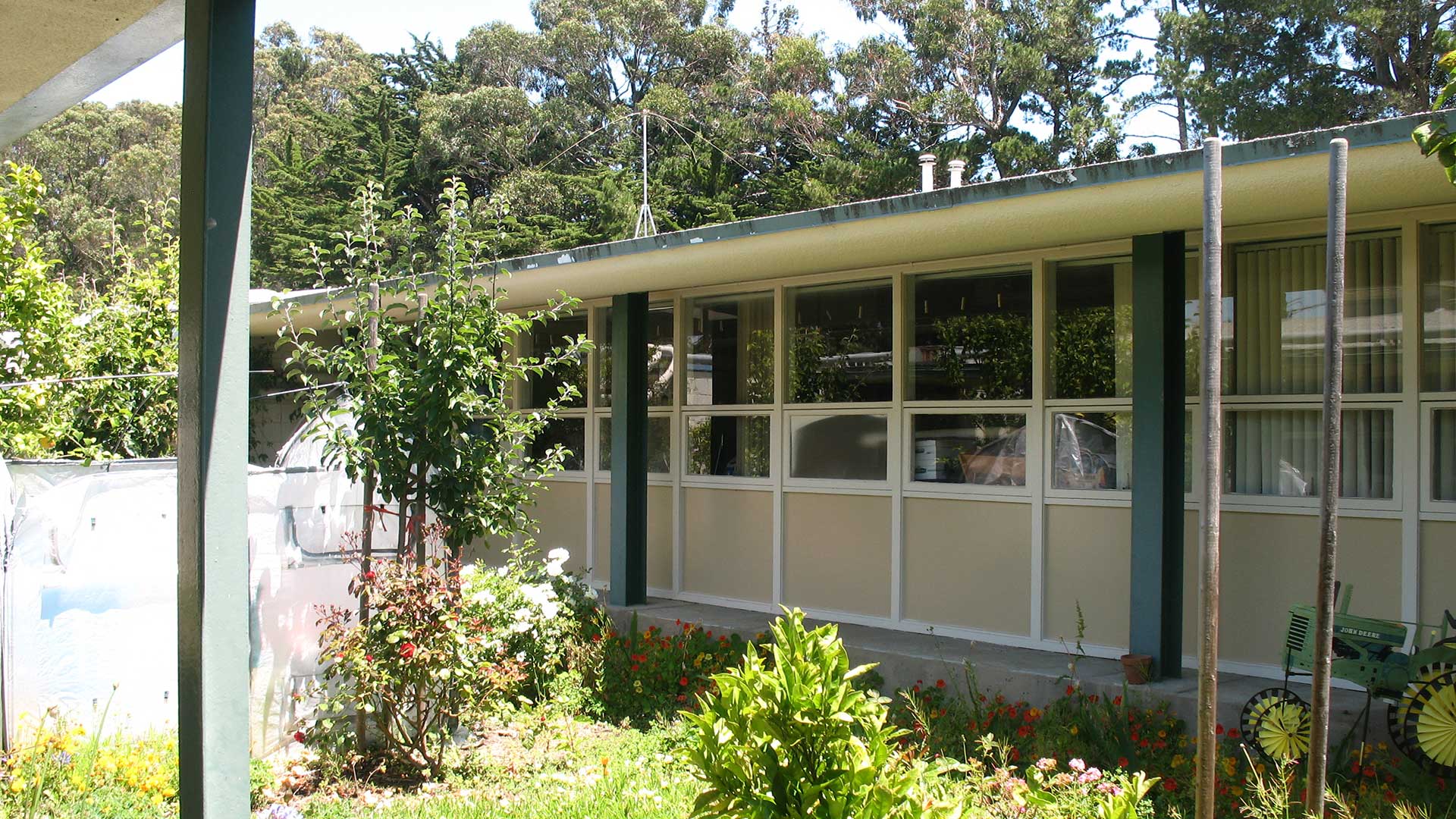 School building with beige walls and green trim, and many windows.