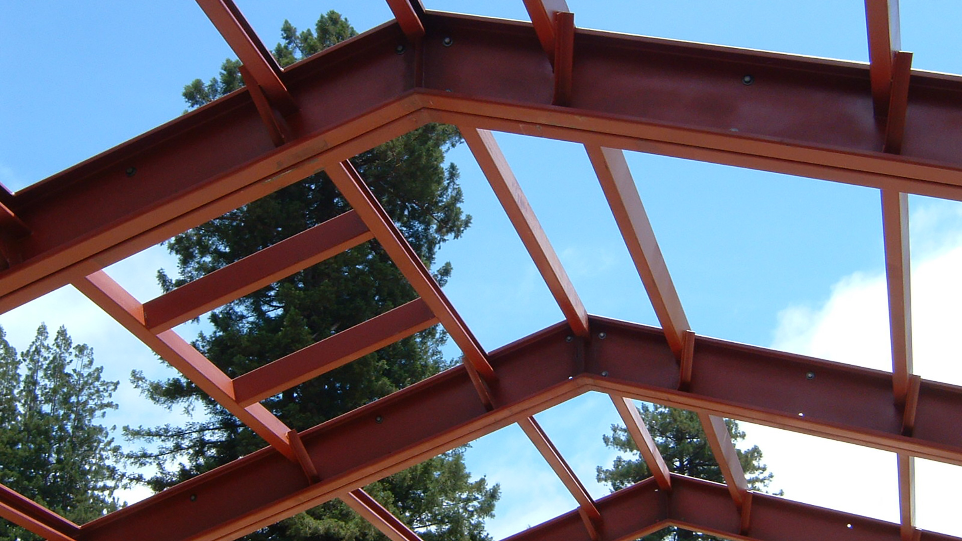 Exposed red metal frame closeup at roof peak.