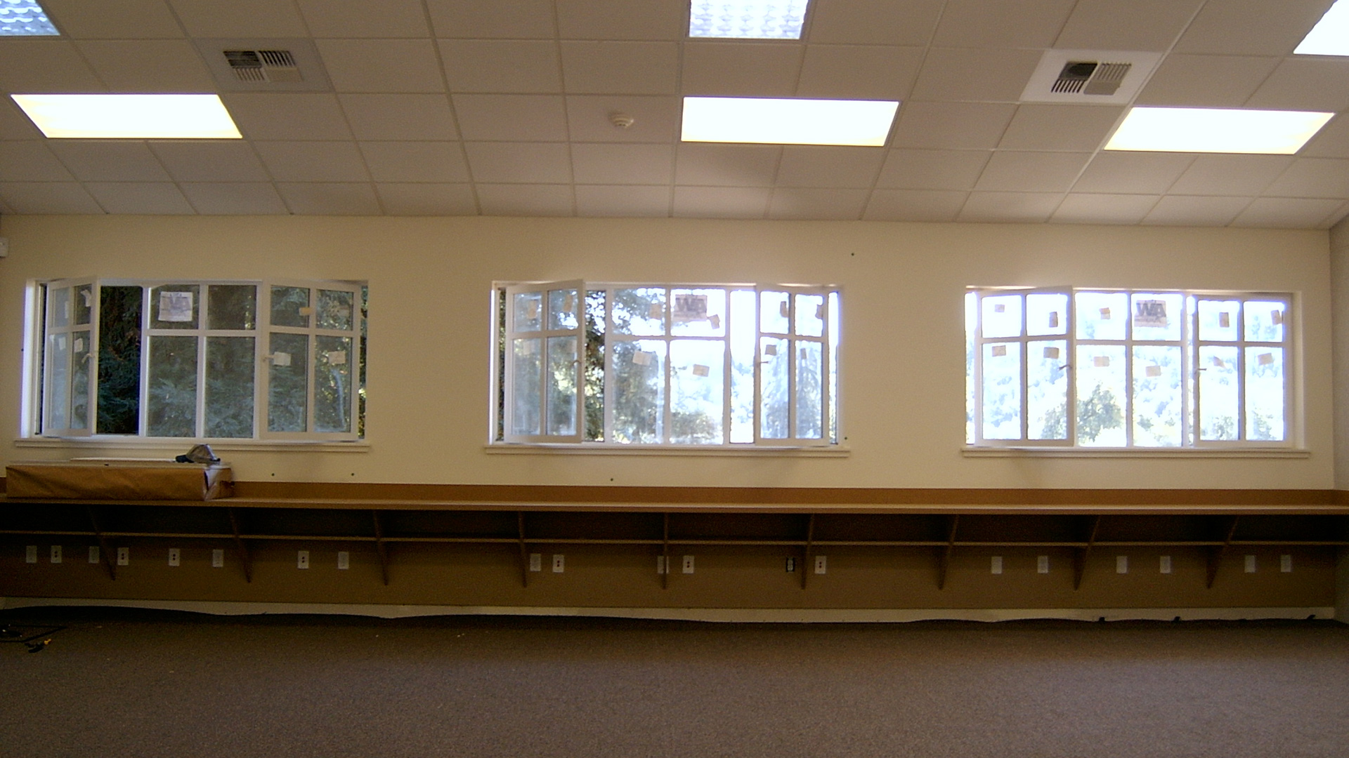 Interior of new classrooms, with vaulted ceilings, operable windows, and brown desks.