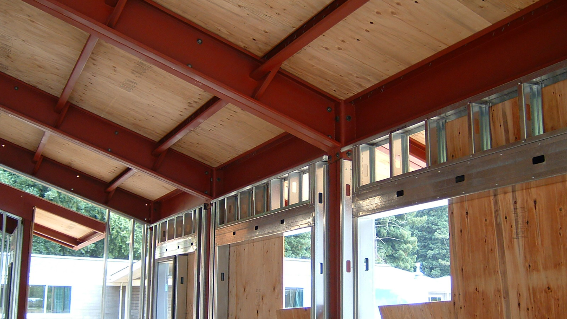 Roof installed on the red metal frame and walls being installed.