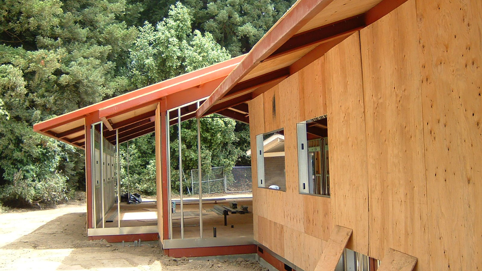 Exterior plywood being installed on wall frames.