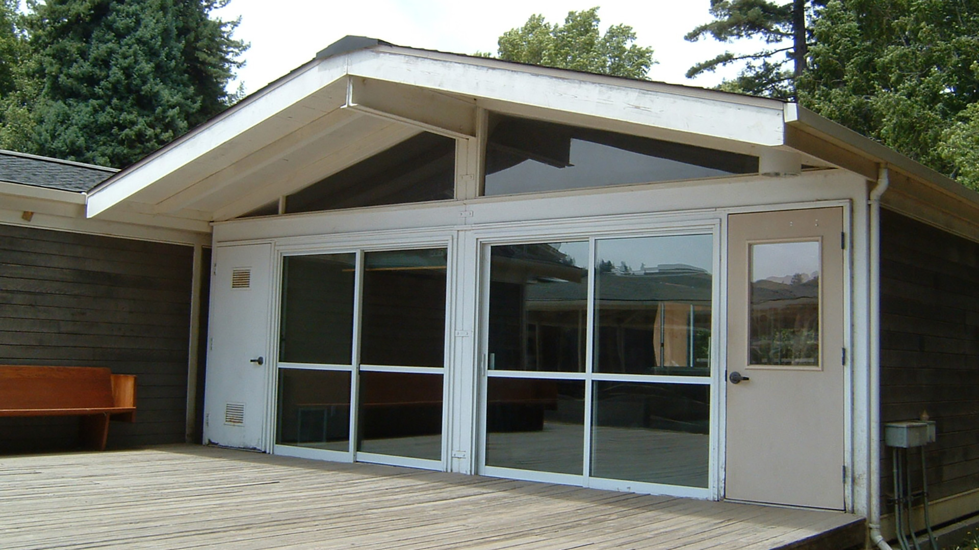 Completed building with gable roof and large vast windows and doors.