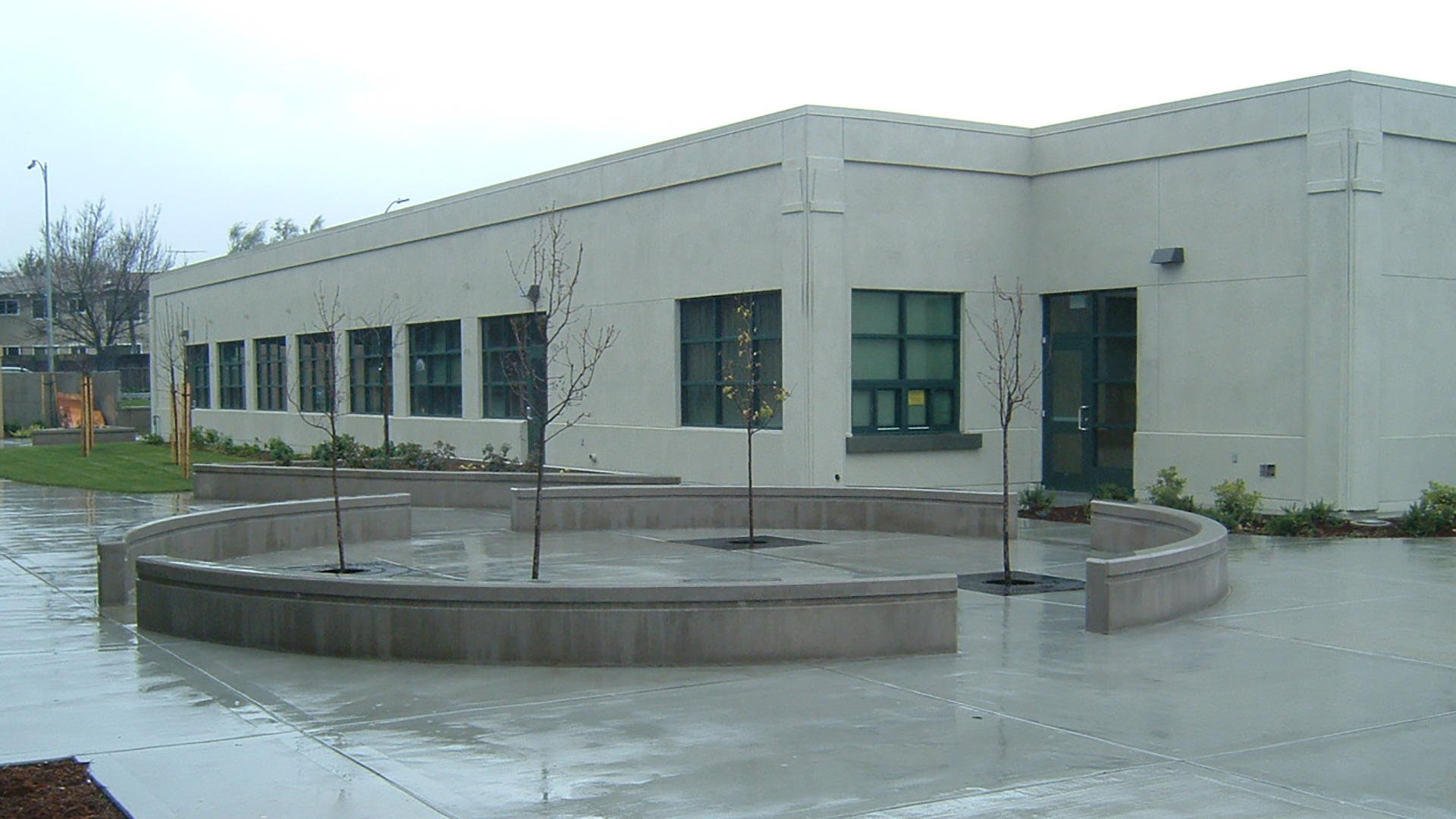 Courtyard in front of district office, with curved concrete benches and sections open for trees