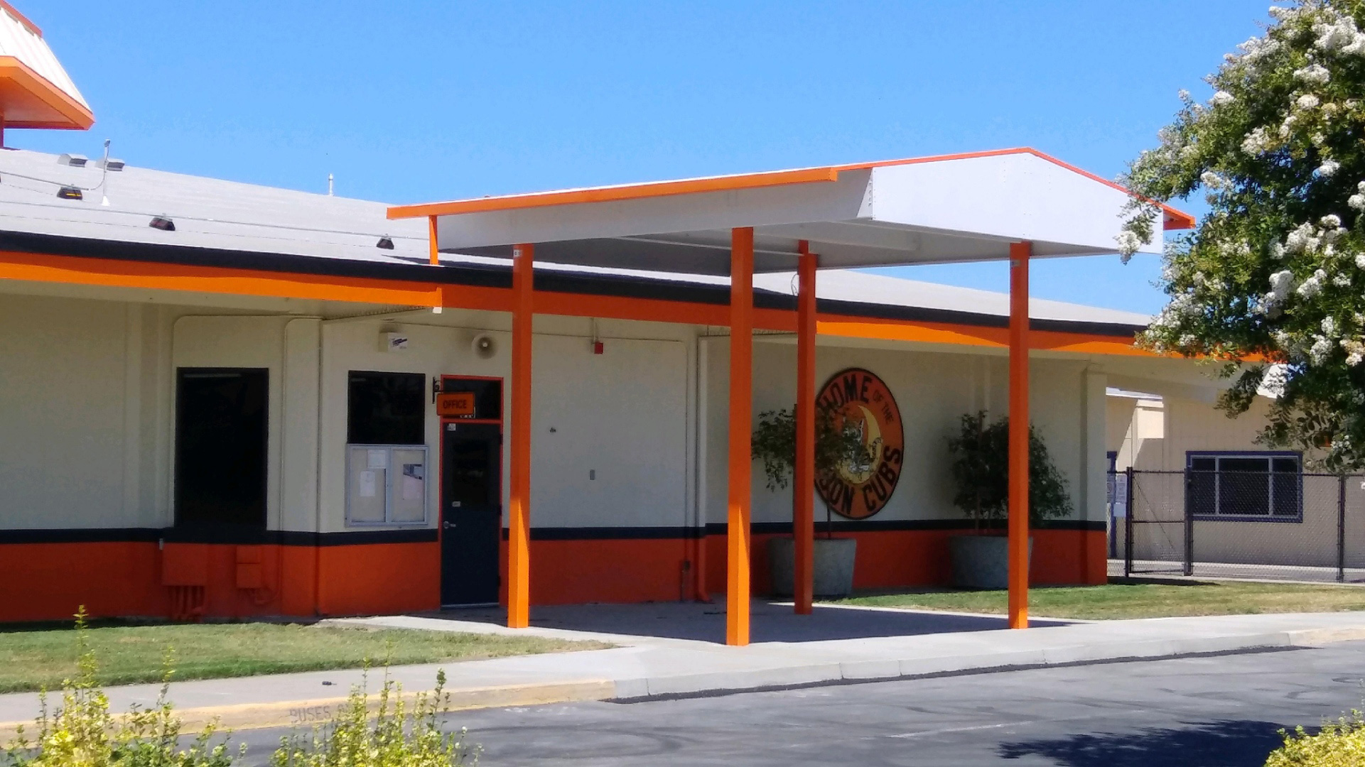 Entryway mid-construction, with unfinished orange poles and white shade structure.