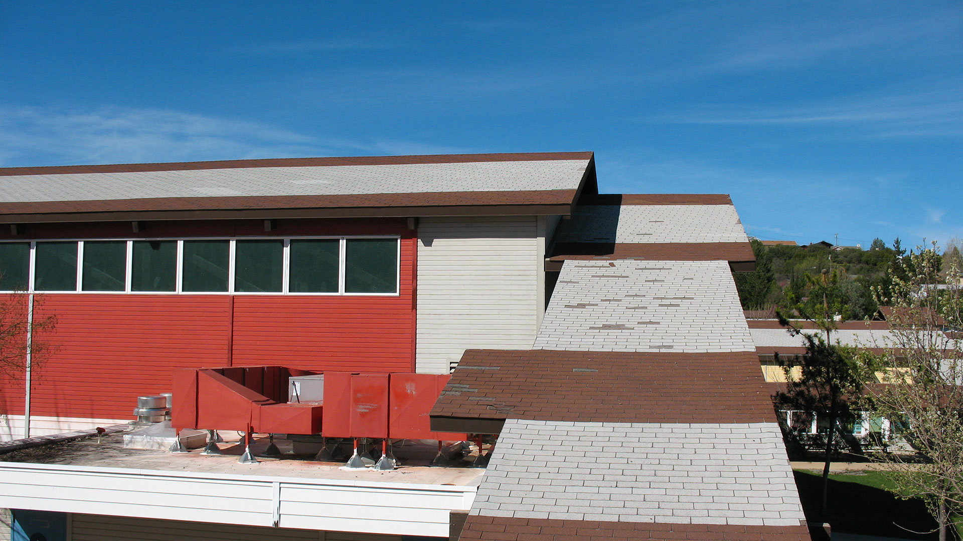 Areas of building highlighting reroof needs, with broken shingles.