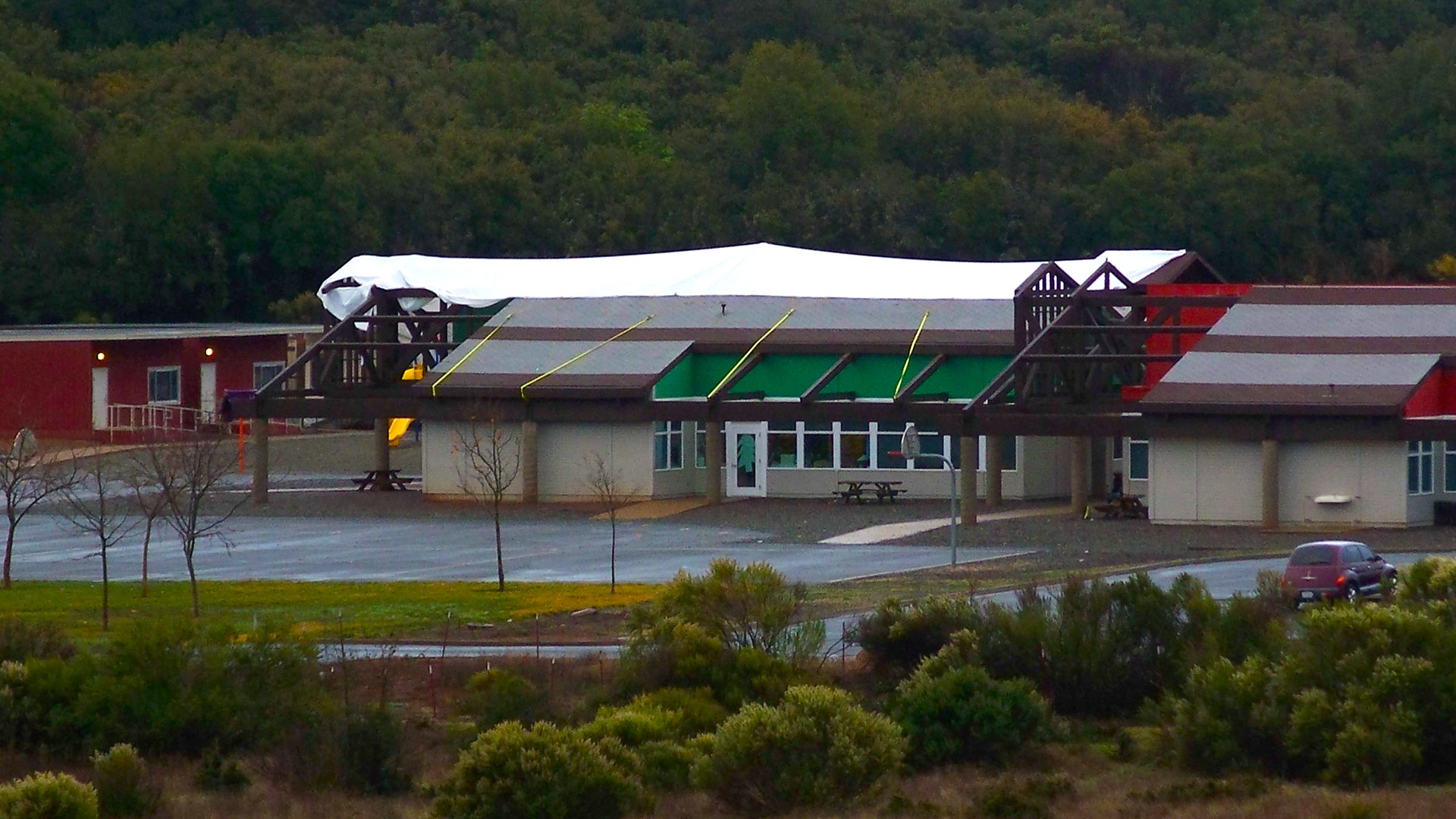 Campus building during reroof, with tarps covering vast sections of roof.