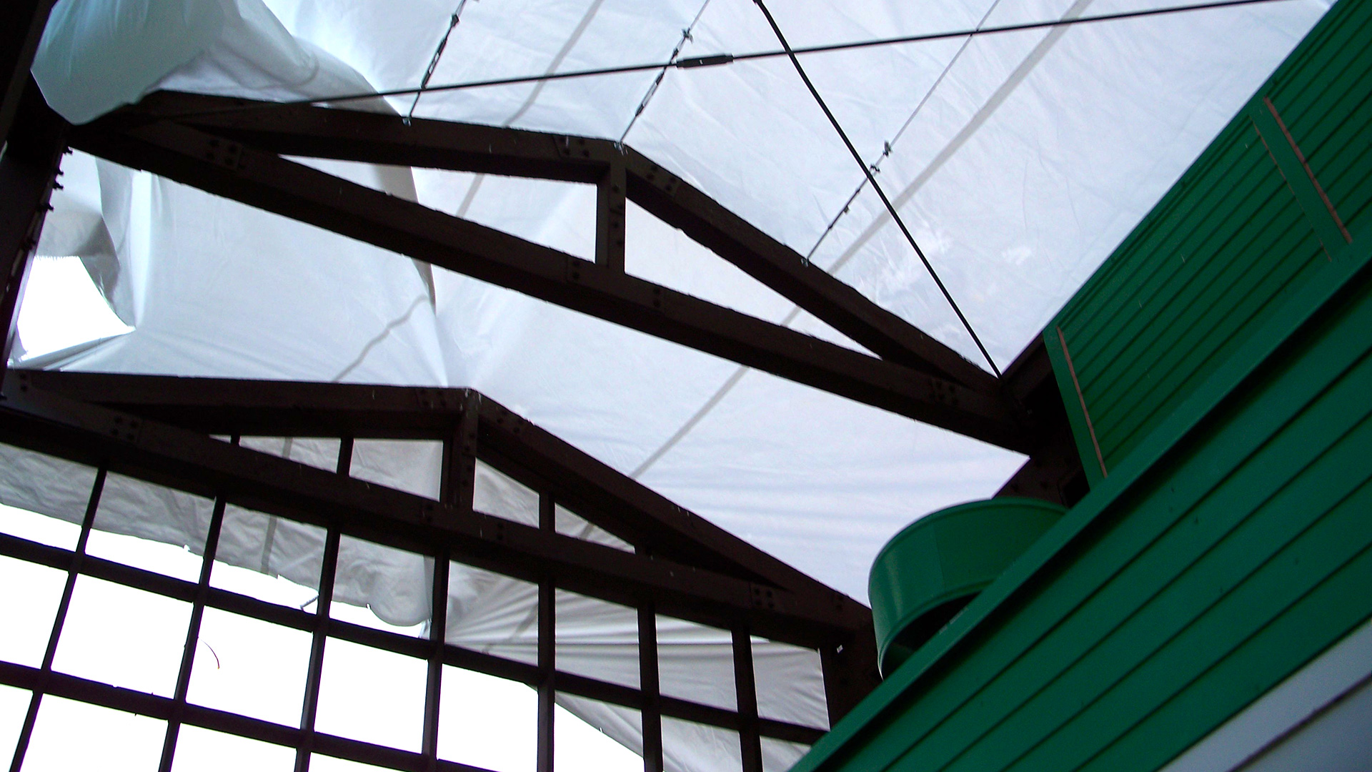 Reroof during construction, with large white tarp pulled over exposed sections.