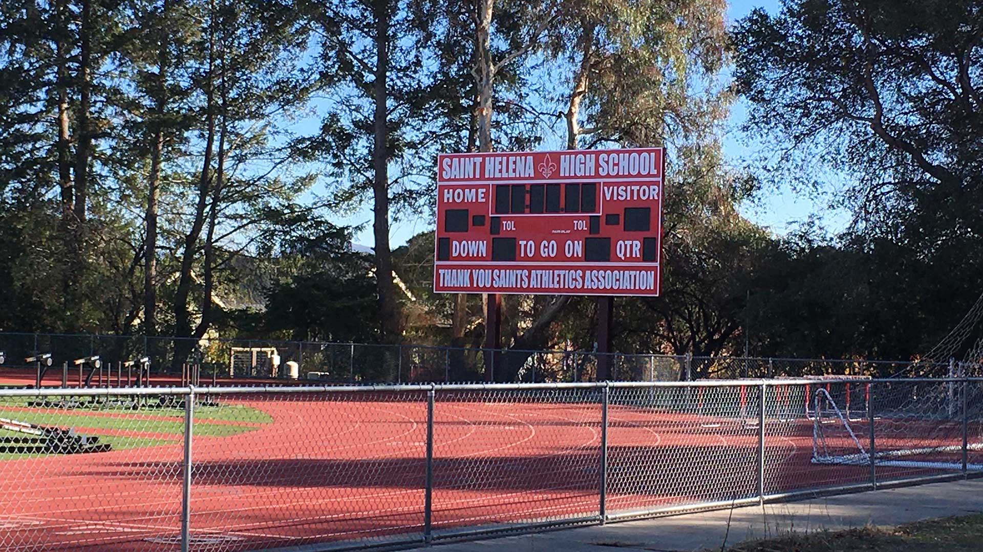 New football scoreboard outside high school playing field.