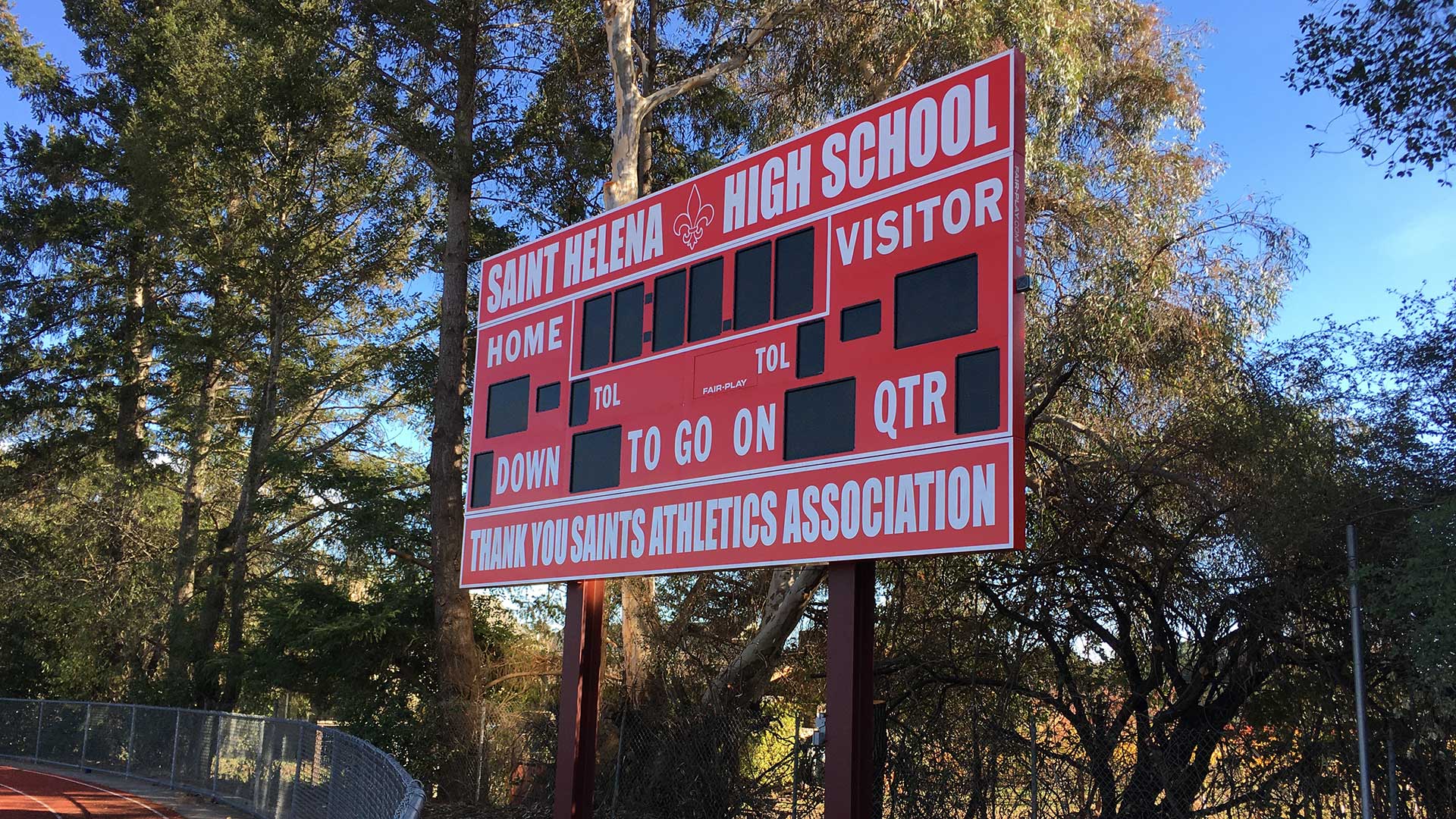 Football scoreboard outside high school playing field.