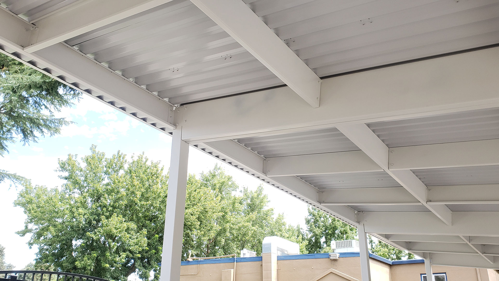 White shade structure from underneath, supports holding currogated metal roof.